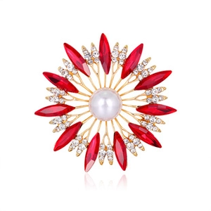 Detail of a golden flower brooch with a large pearl center and red marquise gemstones
