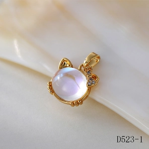 Detailed close-up of a golden cat pendant with iridescent moonstone and crystal bow