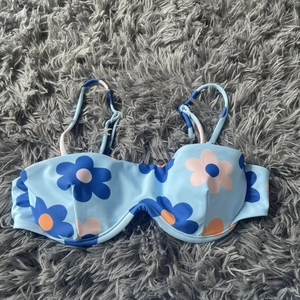 Detail of light blue bikini top with large floral pattern and underwire support