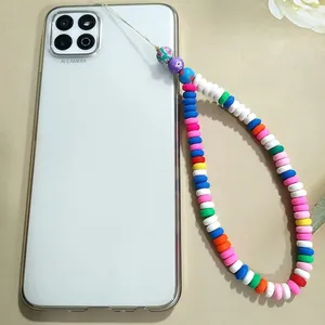 Detail of colorful polymer clay beads and floral charm on a stylish phone lanyard strap