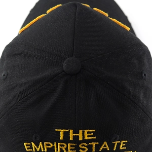 Detail view of gold embroidery on black washed cotton baseball cap with patch decor