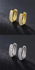 Detailed close-up of gold and silver pavé zircon hoop earrings on a black background