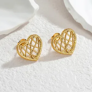 Minimalist gold hollow heart stud earrings with twisted rope texture on a stone background