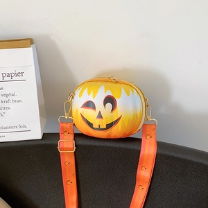 Detail of orange pumpkin-shaped crossbody bag with a patterned strap for Halloween fashion