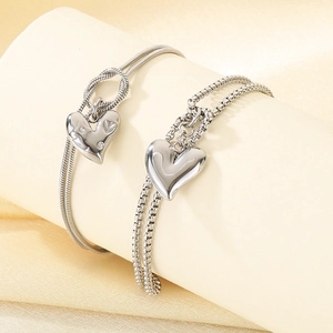 Macro view of double-layer silver titanium steel bracelet featuring heart pendants
