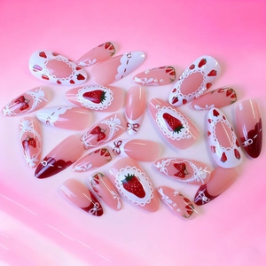 Almond press-on nails featuring pink gradient, red bows, strawberries and pearls