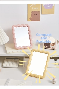 Close-up of pink and beige makeup mirrors with stylish wavy edges on a cozy desktop