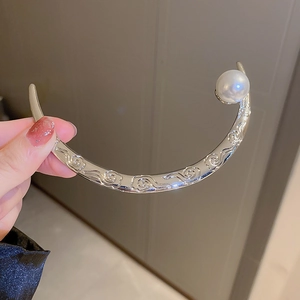 Detailed view of silver crescent hair pin with cloud patterns and large white pearl
