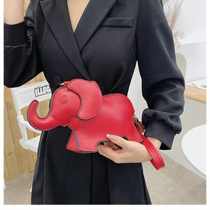 Detail of red elephant-shaped PU leather crossbody bag worn by a model in bright setting