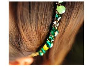 Close-up of headband with green and yellow crystals woven with golden metallic thread