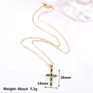 Detailed view of gold cross pendant with green zircon stones, size 14mm by 26mm