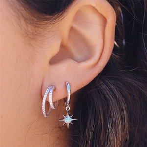 Detailed macro view of S925 sterling silver hoop earrings with star pendant and opal stone