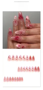 Dettaglio di unghie finte a mandorla con labbra rosse, perle e fiocchi per manicure