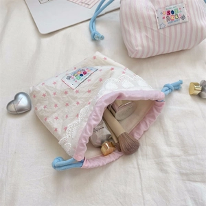 Detailed view of lace drawstring storage bags with star patterns and cotton stripes
