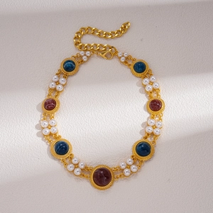 Detail of vintage gold necklace featuring faux pearls and colorful resin gemstones