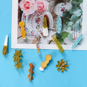 Detalle de 11 horquillas de resina con purpurina y formas de estrellas y margaritas