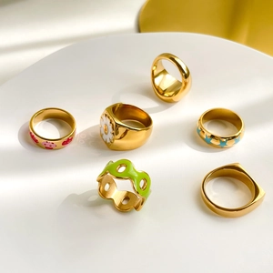 Set of six gold enamel rings featuring colorful flower and geometric patterns