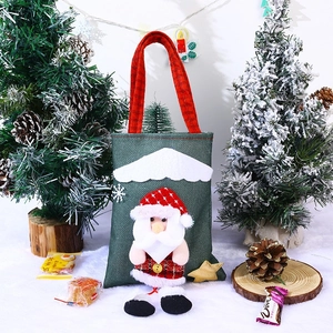 Detailed view of burlap Christmas gift bag with 3D Santa doll and red plaid handles