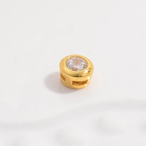 Macro shot of a gold-plated round cubic zirconia charm with a polished finish