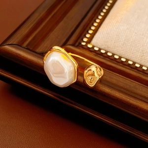Détail macro d'une perle ovale sertie sur une bague ajustable dorée texturée