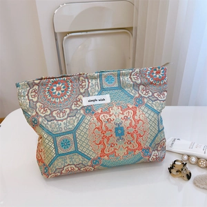 Detailed macro of vintage jacquard fabric cosmetics bag with gold floral patterns