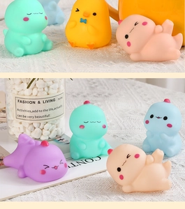 Close-up of soft colorful vinyl dinosaur and duck toys on a white lace background