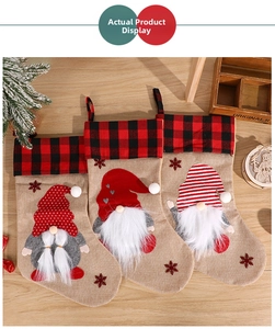 Detailed close-up of three burlap Christmas stockings with gnome embroidery and red plaid trim