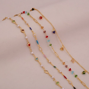 Detailed close-up of four gold bracelets featuring colorful gems, pearls and heart charms