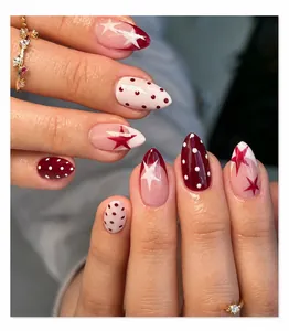Macro detail of red and white almond press-on nails with star and polka dot patterns