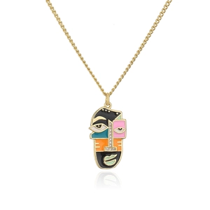 Macro shot of 18K gold-plated abstract face pendant with colorful enamel and zircon stones
