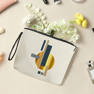 Abstract geometric makeup bag with gold and navy patterns and convenient black wristlet strap