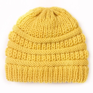 Detailed knit texture of bright yellow winter beanie for babies on a clean white background