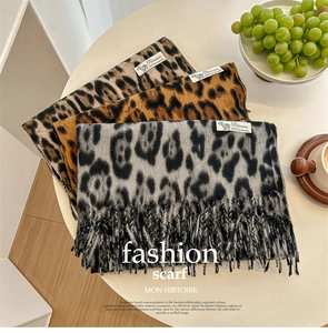 Detailed view of leopard print cashmere scarves in grey and brown with fringe edges