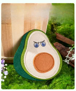 Detail of felt avocado cat toy with angry expression on mossy decorative background