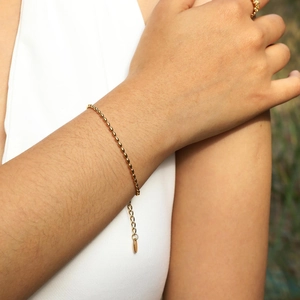 Close-up of golden beaded stainless steel chain bracelet worn on a female wrist