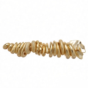 Golden multi-textured layered rings hair clip with polished surface and leaf accents