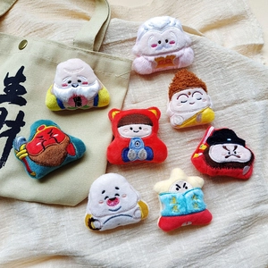 Vue détaillée de badges brodés en peluche avec des dieux de la fortune sur un sac en toile
