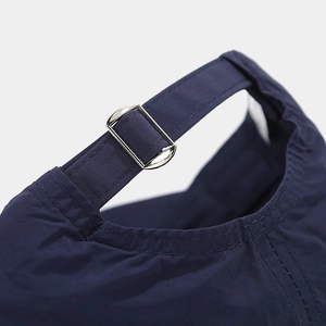 Vue détaillée de la boucle en métal réglable et du tissu bleu marine de la casquette