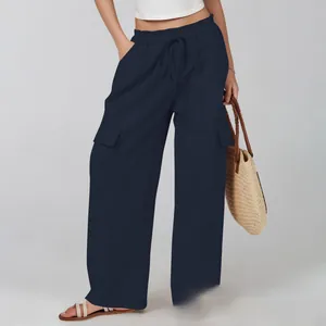 Detail of loose fit cotton linen pants featuring drawstring waist and flap cargo pockets
