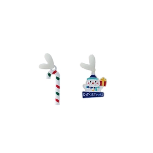 Detail of asymmetric Christmas earrings featuring a candy cane and a cute snowman