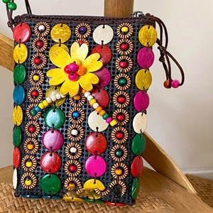 Detail of bohemian handmade beaded coin purse with colorful floral shell and mesh texture