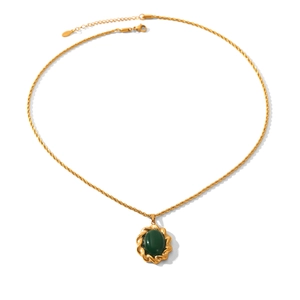 Detail showing vintage gold twisted chain and oval green gemstone pendant on white background