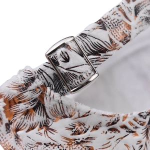 Detailed macro view of the silver metal adjustable buckle and feather print on white cap