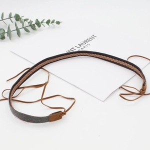 Detail of hand-woven leather hat band with contrast braiding and adjustable ties