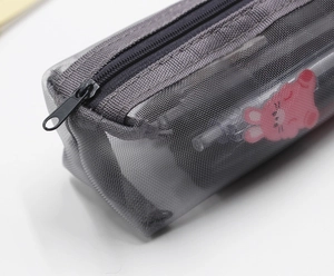 Close-up of grey mesh pencil case zipper detail with cute pink cartoon rabbit print