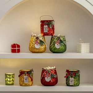 Christmas glass candle holders in red, gold and green with pinecones and festive ribbons