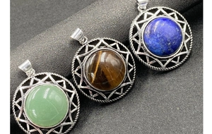 Detailed view of hexagram crystal pendants in green, brown, and blue stones with silver frames