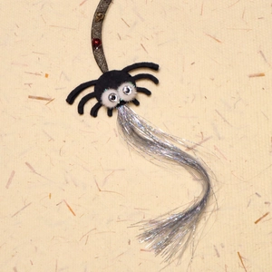 Close-up of spider cat toy with large googly eyes and shimmering silver fringe tassels