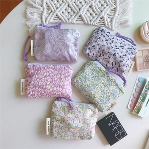 Vue à plat de mini porte-monnaie en coton fleuri avec étiquettes et tirettes mauves