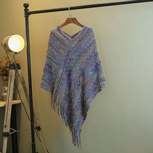 Poncho en maille avec rayures multicolores et ourlet à franges élégant sur cintre en bois